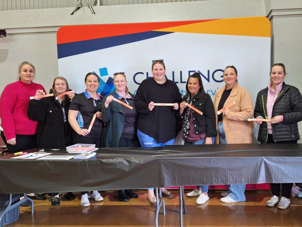 Foster care team standing at the entry table holding event wrist bands